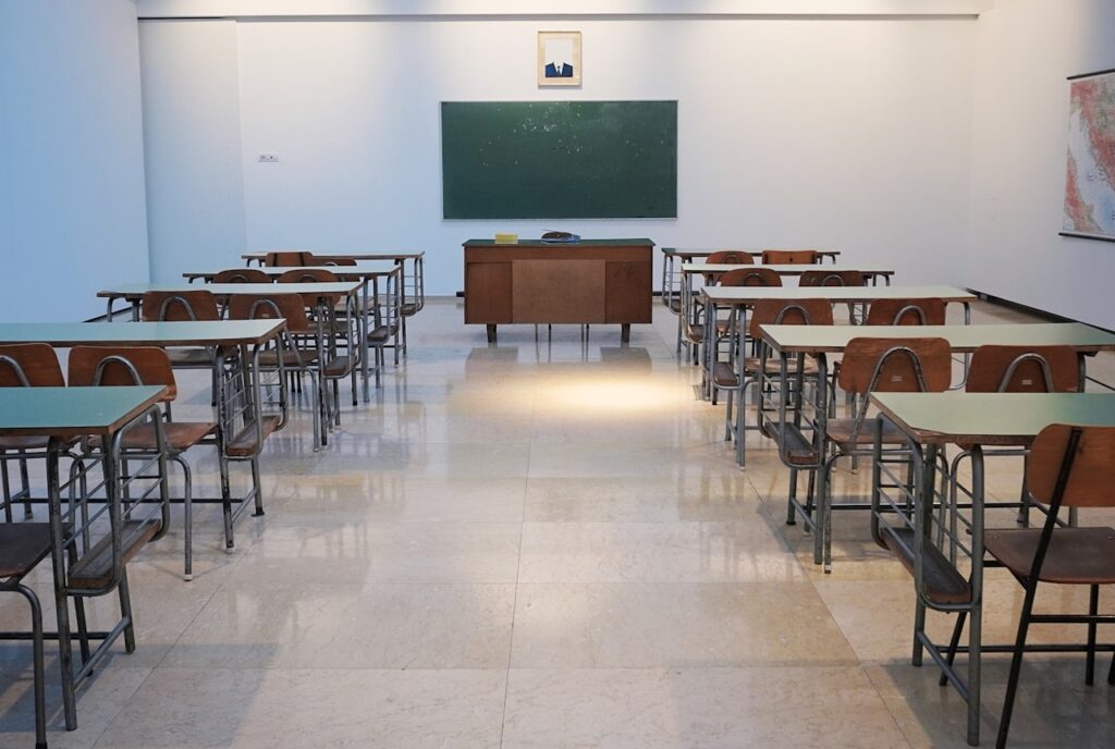 Lớp học đào tạo với bảng xanh, bàn giáo viên và các dãy bàn học